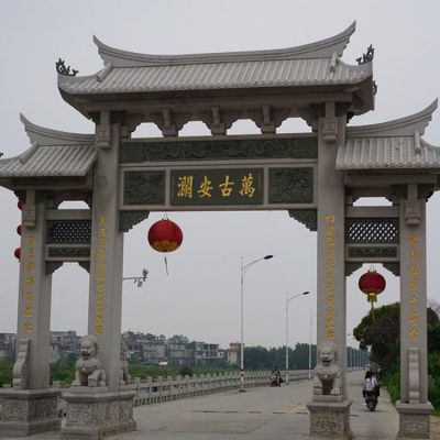 村口擺放青石雕刻仿古三門石牌坊